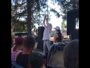 Skeptical lady pulls sword from sword swallower at North Idaho State Fair in Coeur d'Alene