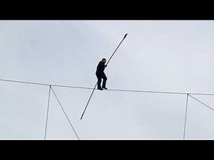 Daredevil walks on high wire between two building at the National Harbor